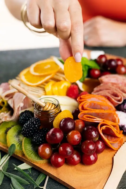 Bamboo board with three cheeses, cured meats, fruit and crackers for 4 to 6 people (view 2)