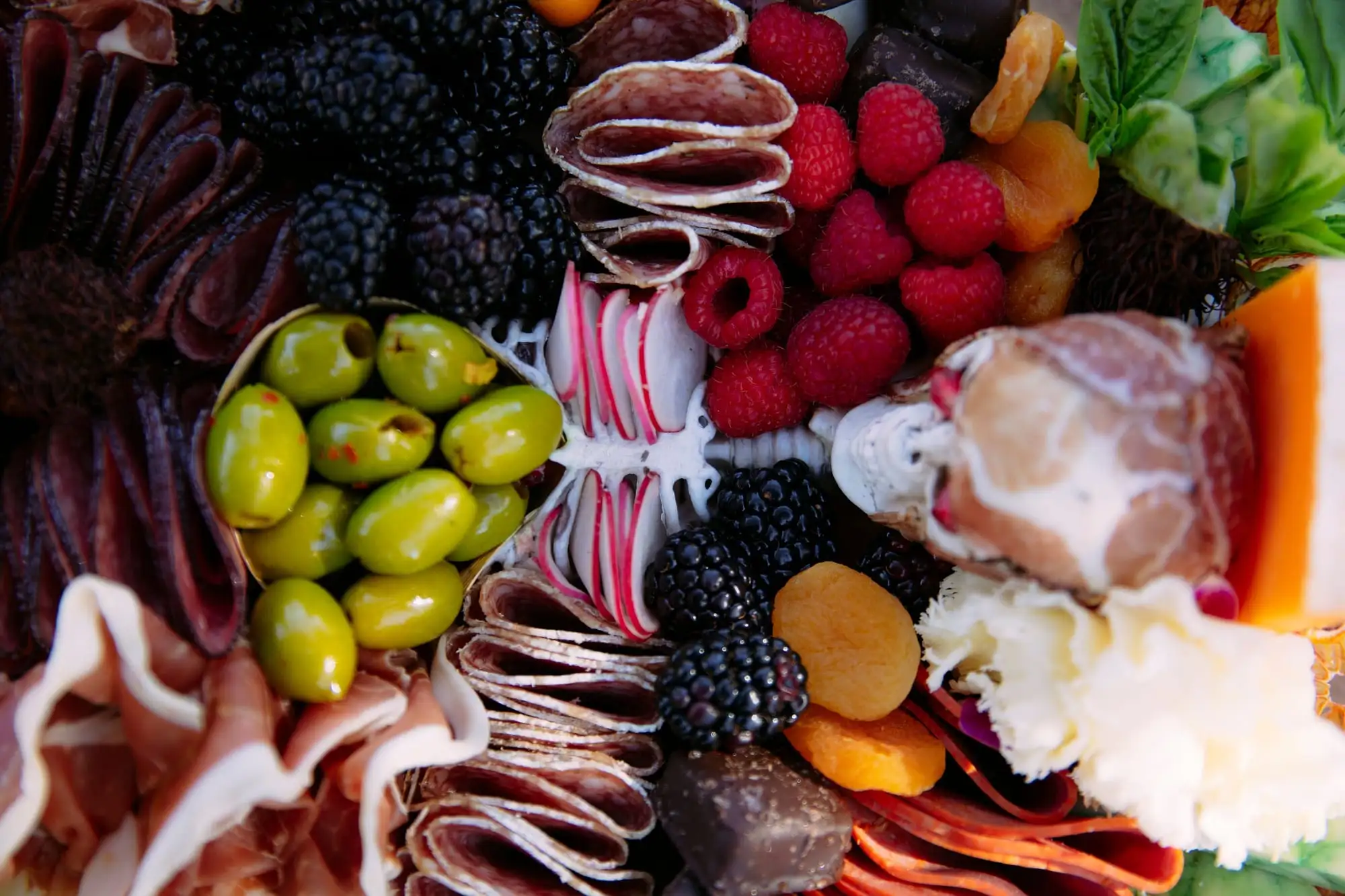 Skeleton charcuterie board for Halloween with a cheese tombstone, salami arms and olive fingers (view 7)