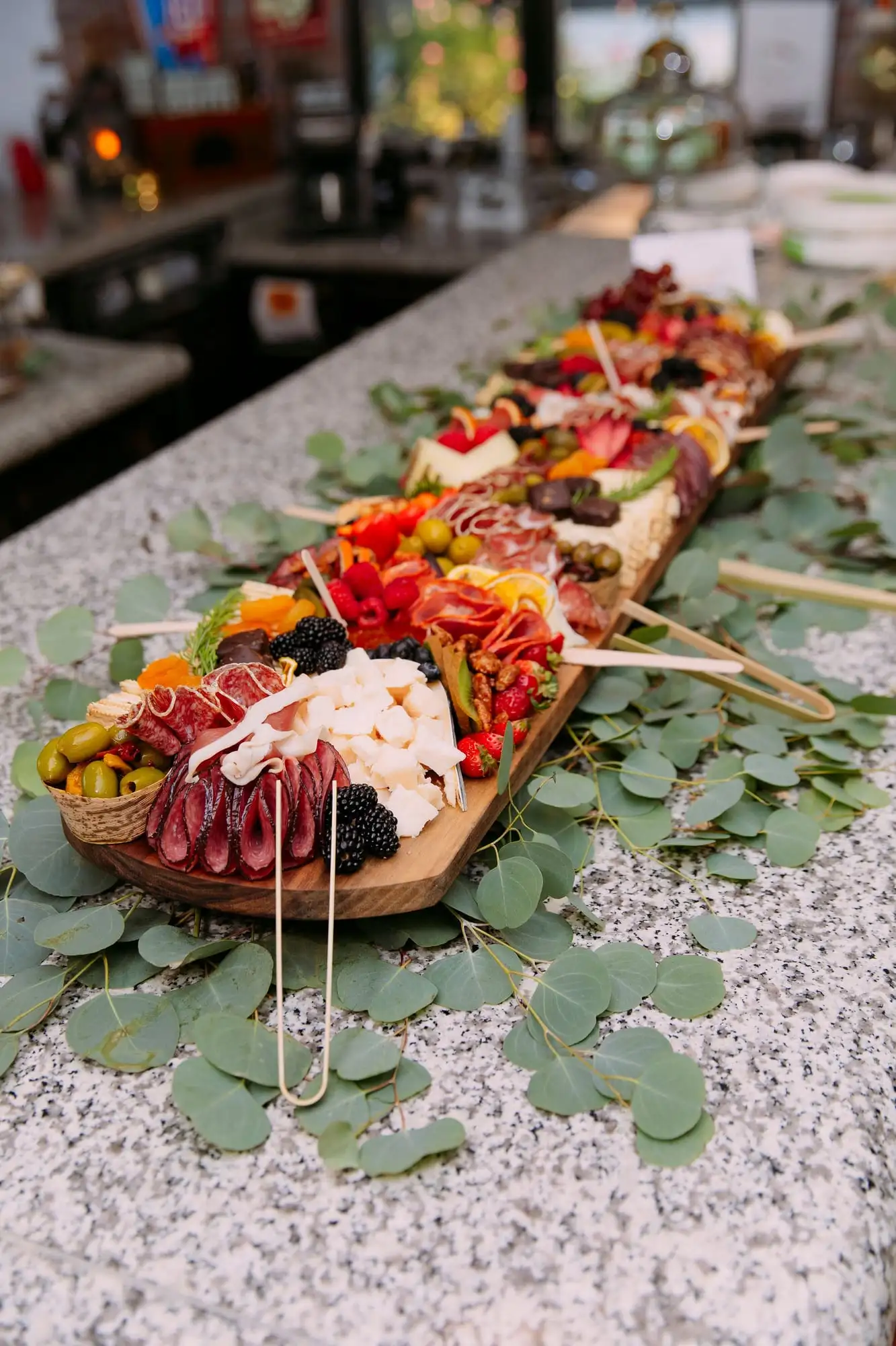 Long charcuterie board with cheeses, cured meats, fruit and chocolates for 30 guests (view 2)