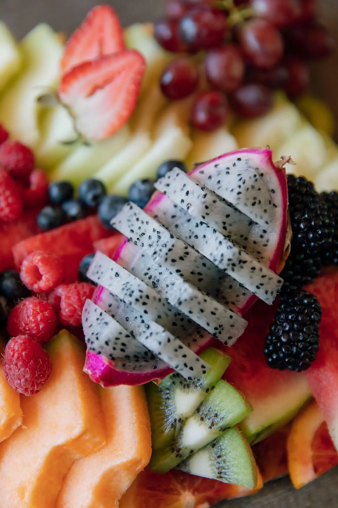Board of fresh seasonal fruit garnished with herbs (view 3)