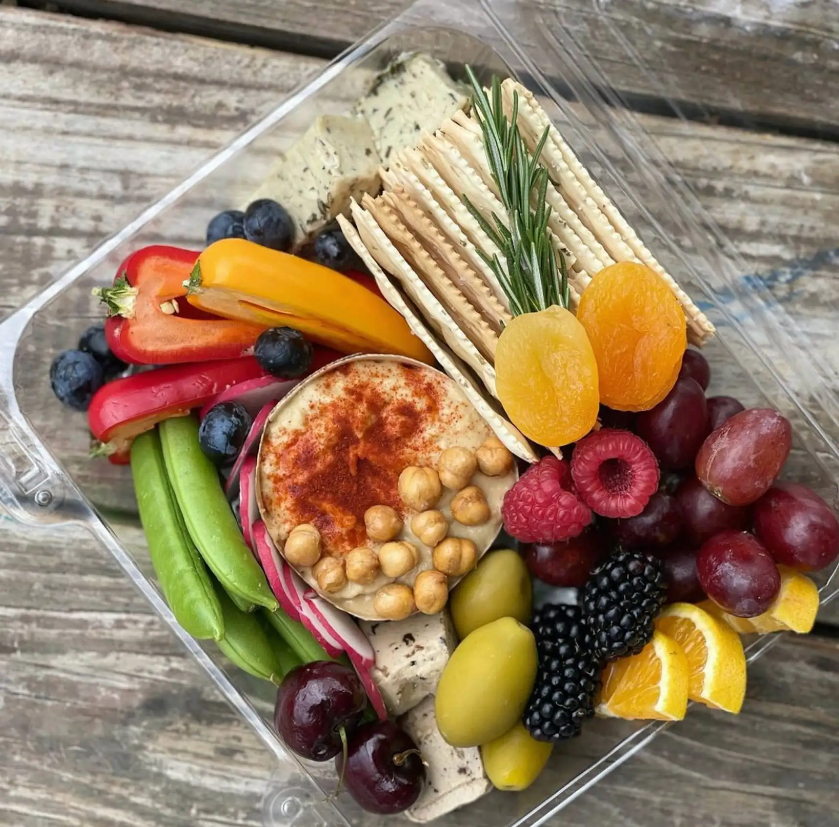 Individual box with vegan cheeses, hummus, vegetables and fruit