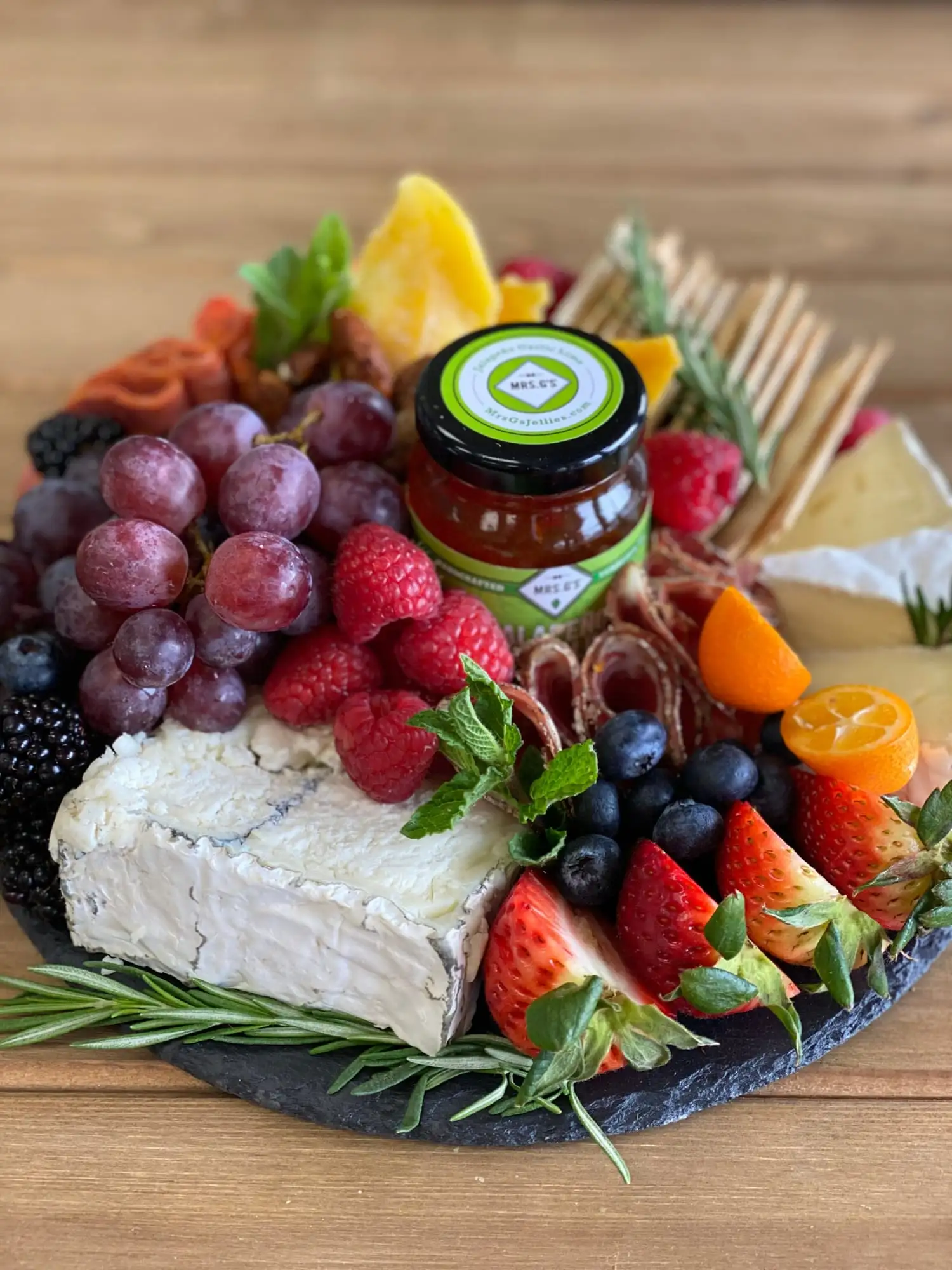 Round board of cheeses, cured meats, fruit and nuts for 4 to 6 people