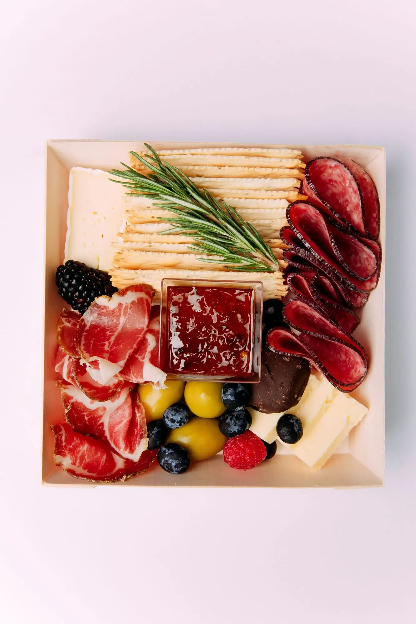Individual charcuterie box with brie, salami, crackers, olives and fruit (view 4)