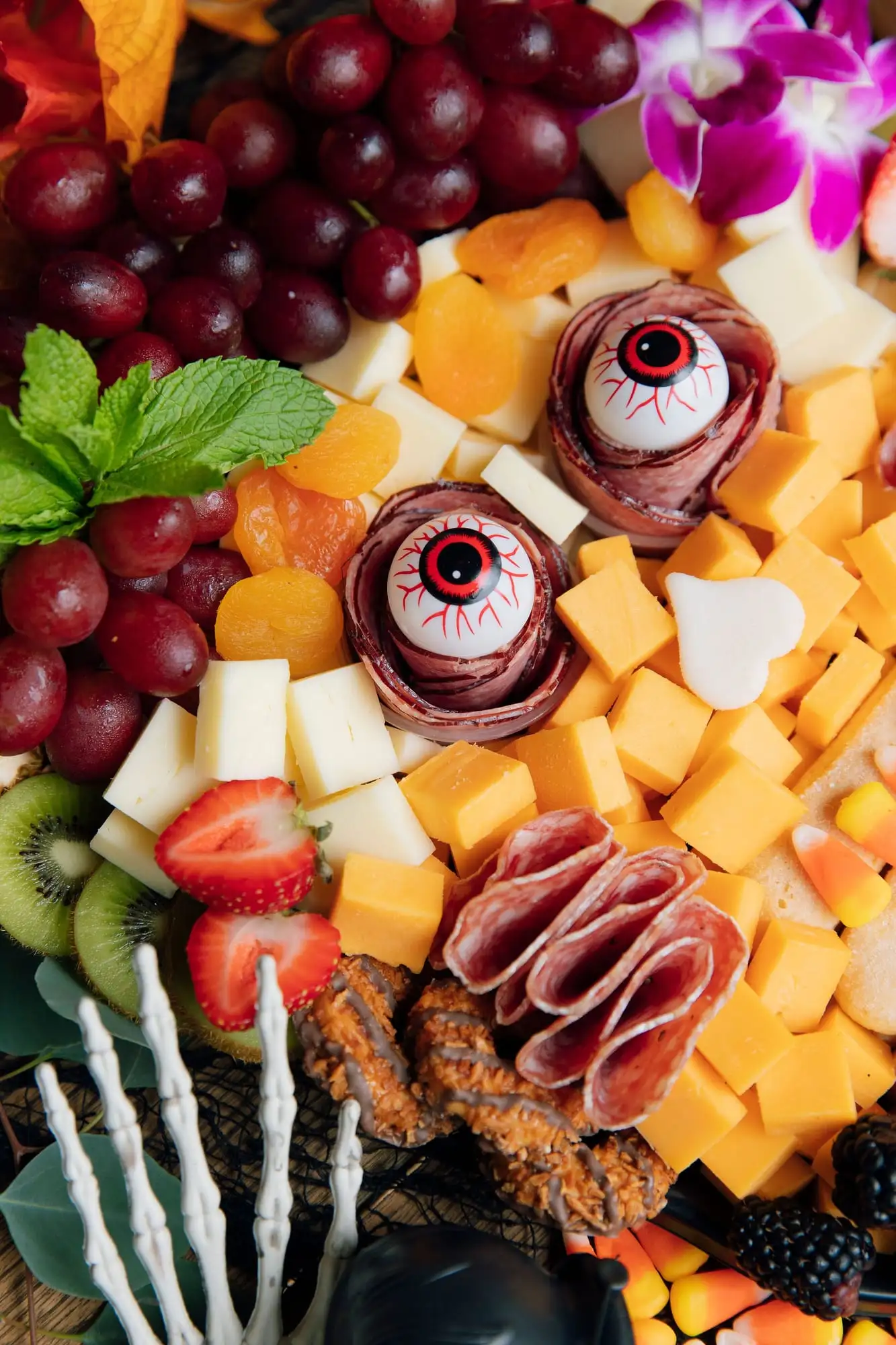 Kids Halloween charcuterie board with sweet and savory treats and candy eyeballs