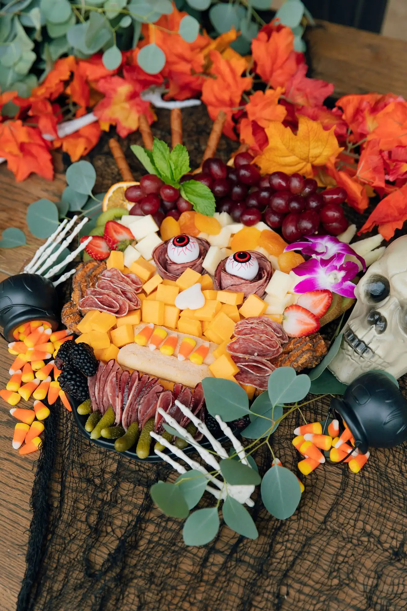Kids Halloween charcuterie board with sweet and savory treats and candy eyeballs (view 2)