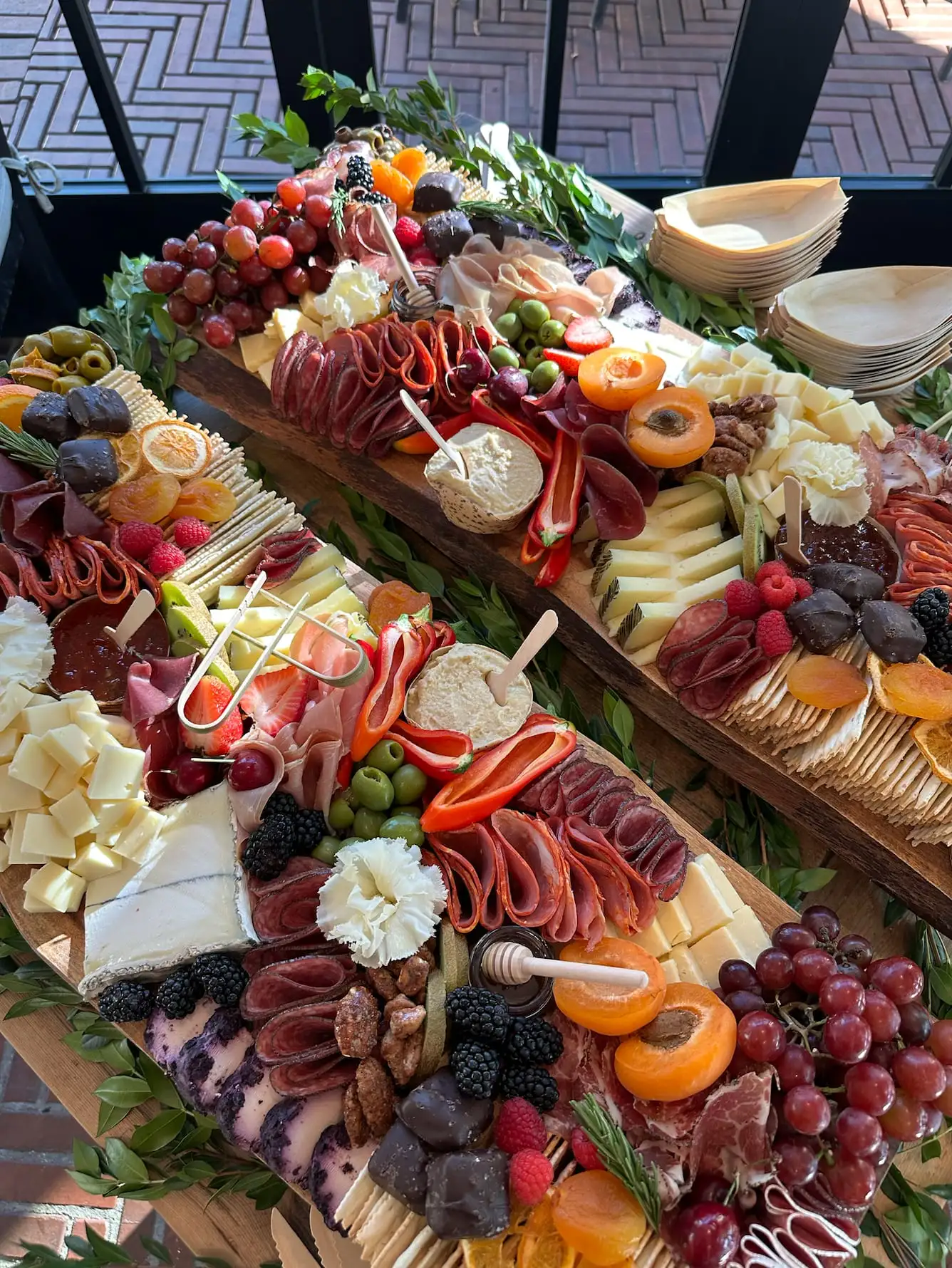 Charcuterie board for 20 guests with cheeses, cured meats, breads and fresh fruit