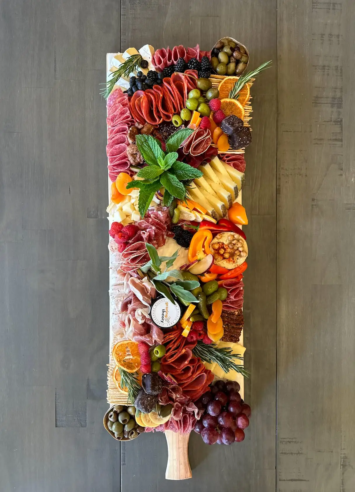 Charcuterie board for 20 guests with cheeses, cured meats, breads and fresh fruit (view 2)