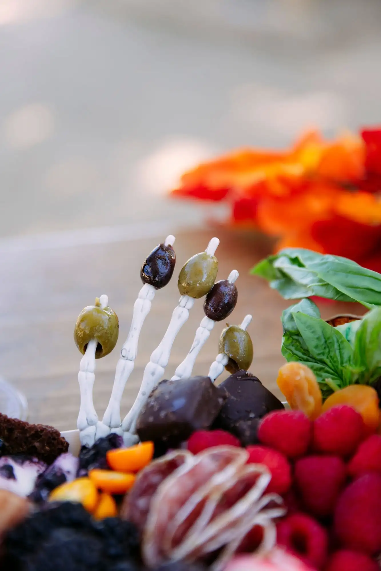 Skeleton charcuterie board for Halloween with a cheese tombstone, salami arms and olive fingers (view 5)