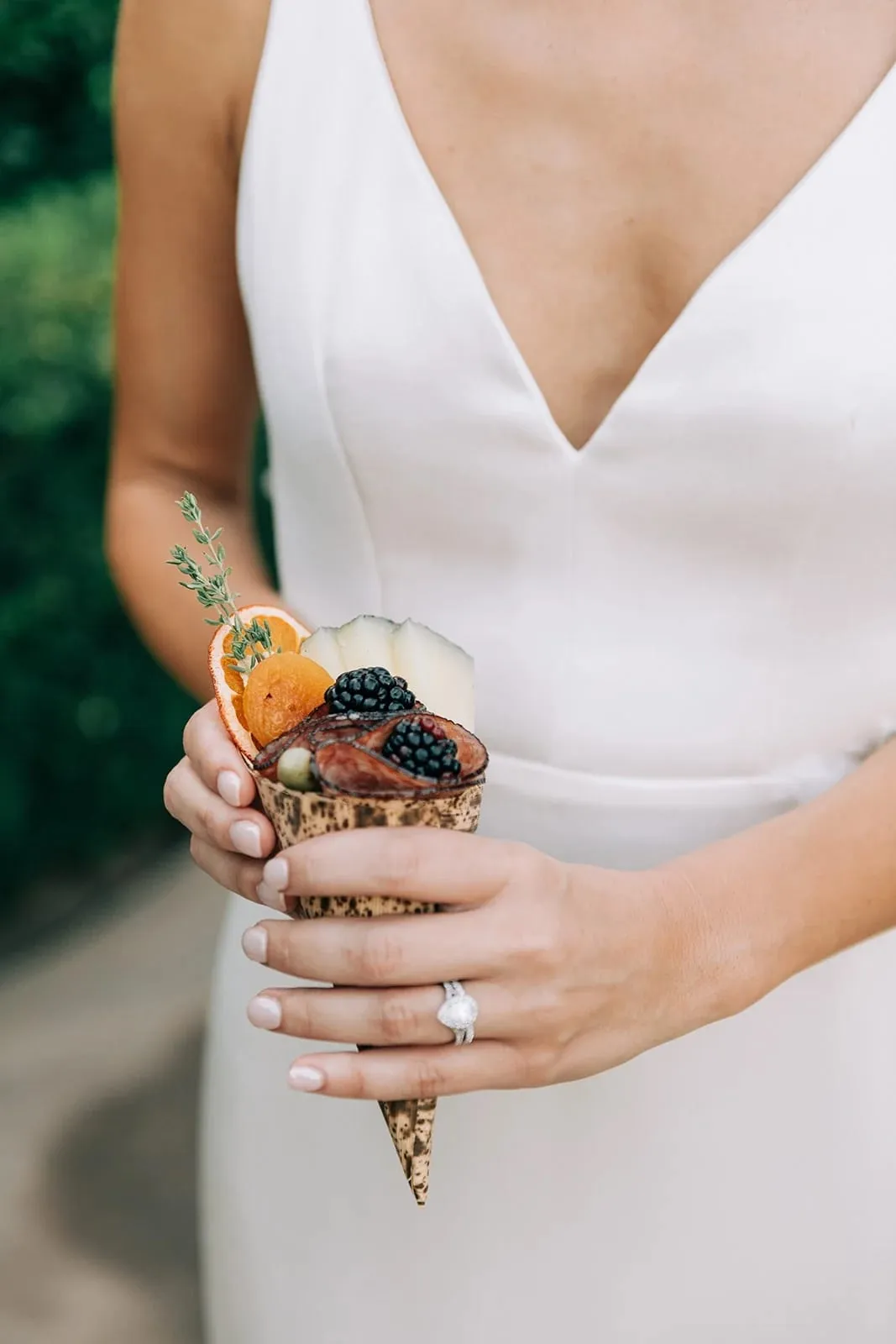 A bride holding a single-serve charcuterie cone