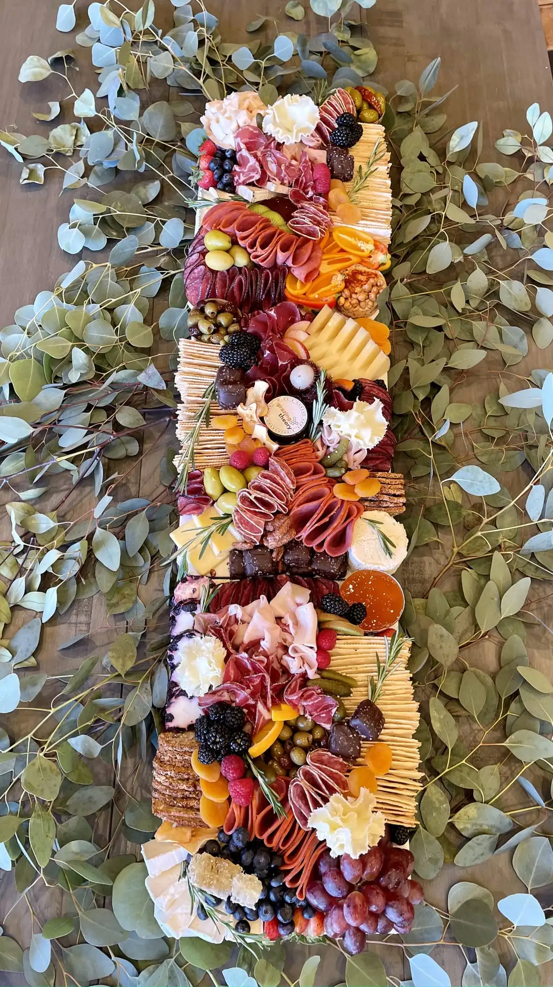Long charcuterie board with cheeses, cured meats, fruit and chocolates for 30 guests (view 4)