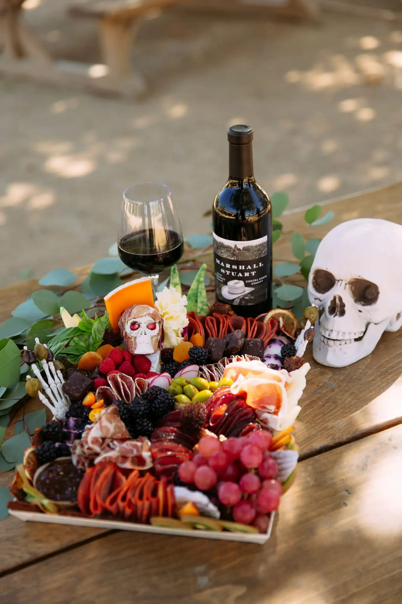 Skeleton charcuterie board for Halloween with a cheese tombstone, salami arms and olive fingers (view 6)