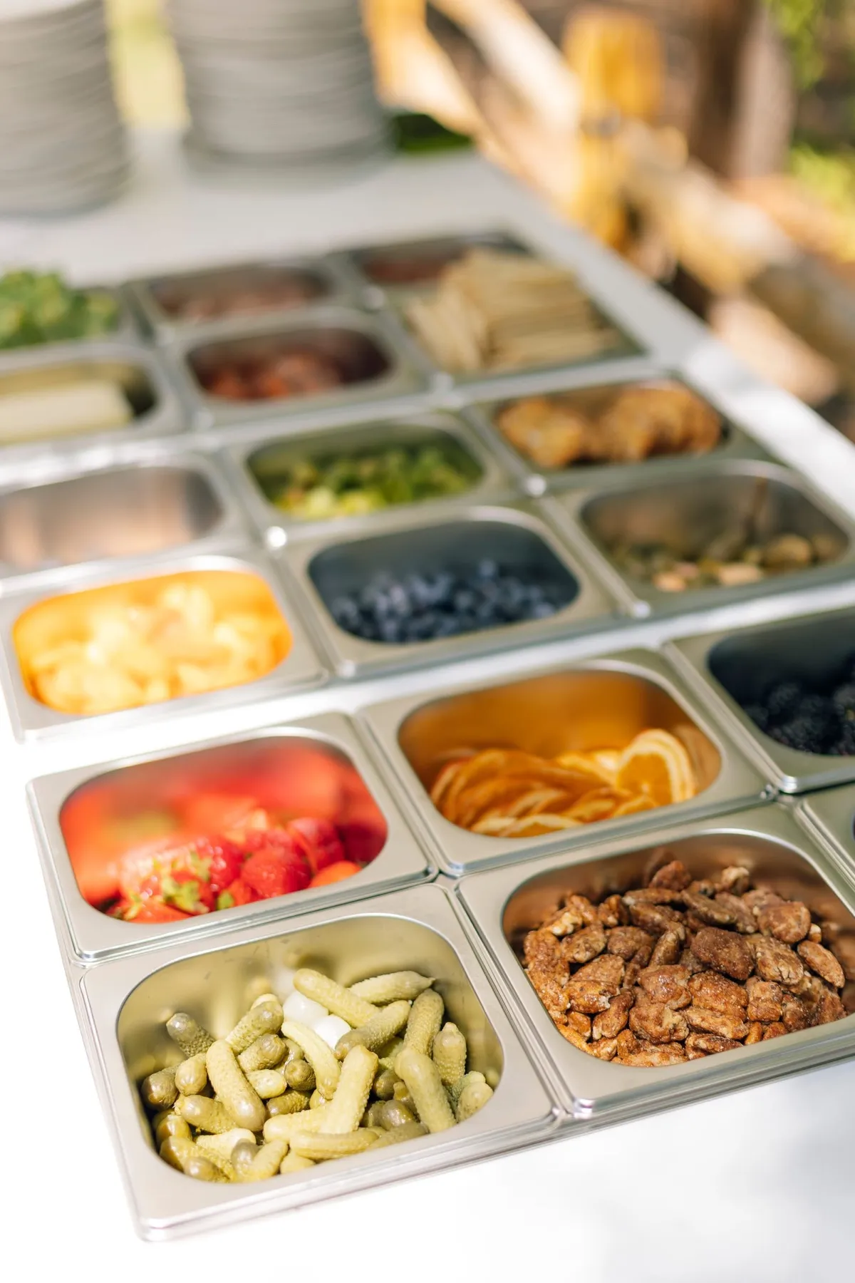 Trays of fruit, cured meats and pickles on the charcuterie cart