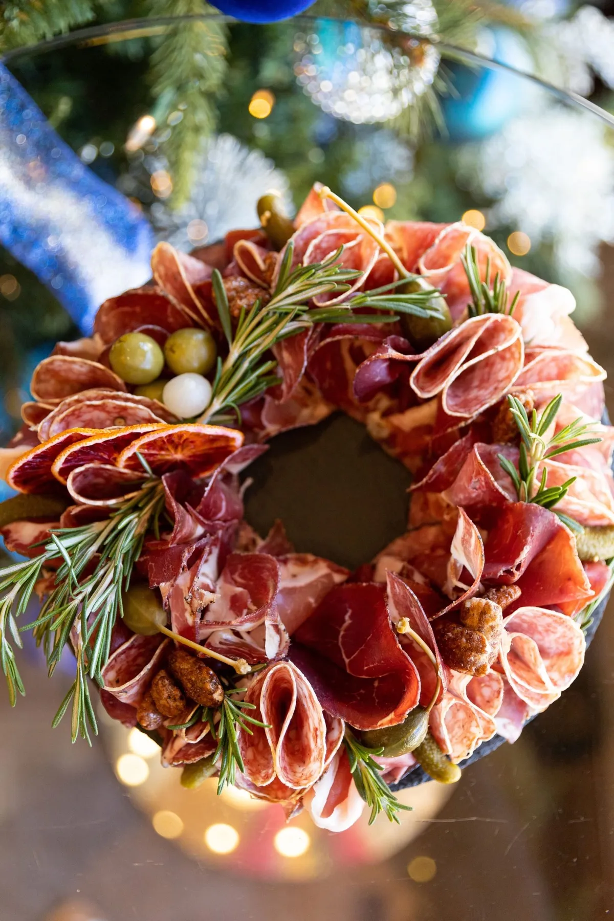 A round charcuterie wreath with cured meats and greenery