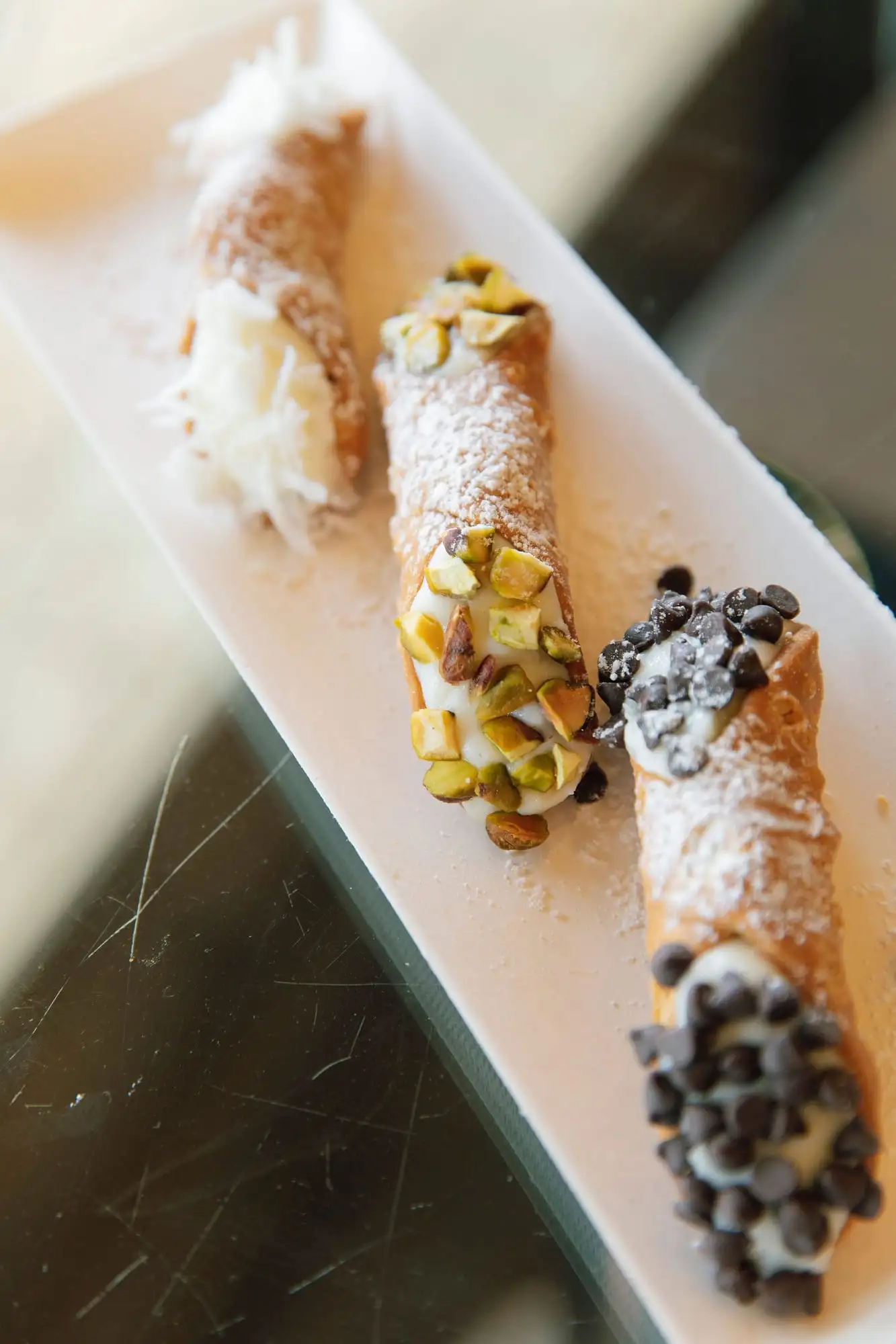Ricotta-filled cannoli dusted with powdered sugar (view 2)