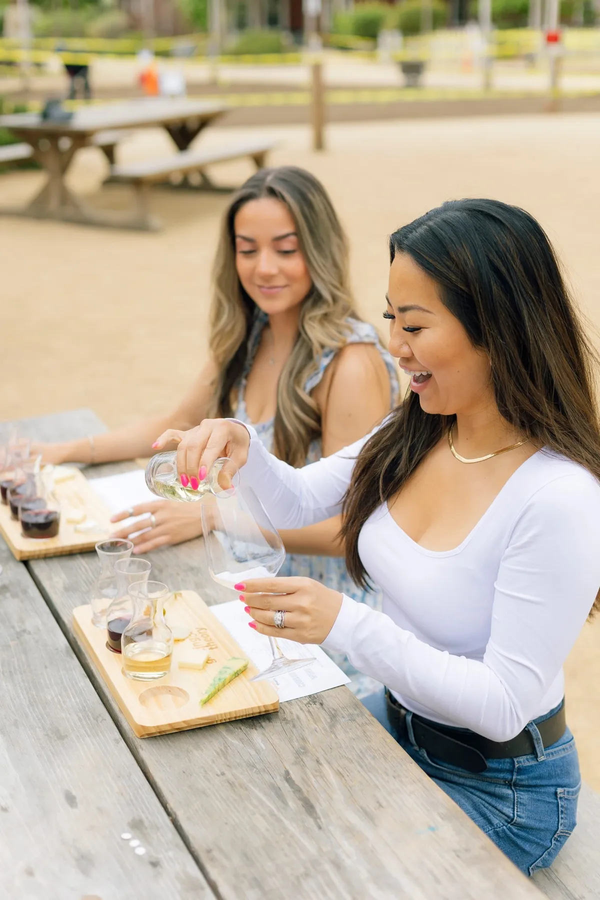 Friends tasting wine and cheese at an outdoor table
