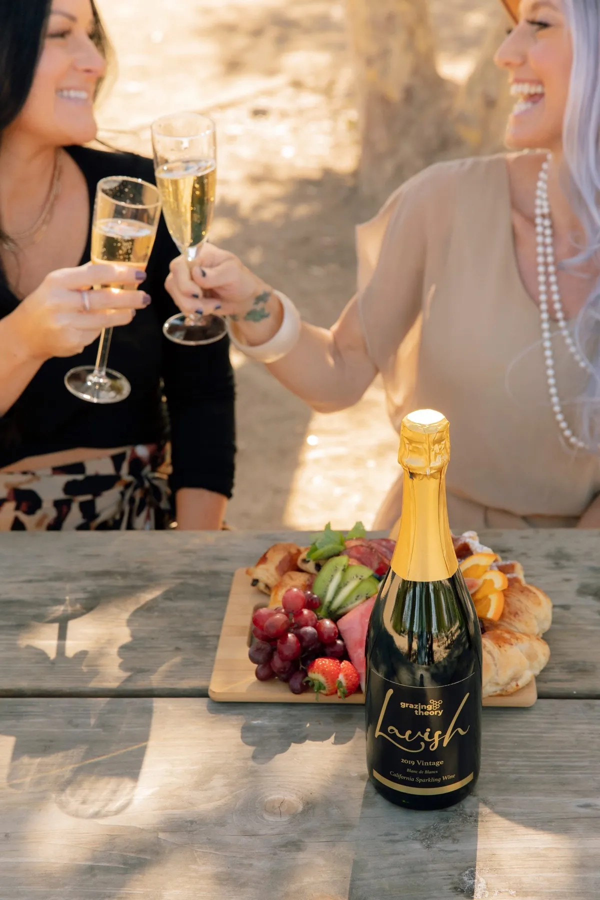 Friends toasting with glasses of sparkling wine over a charcuterie board