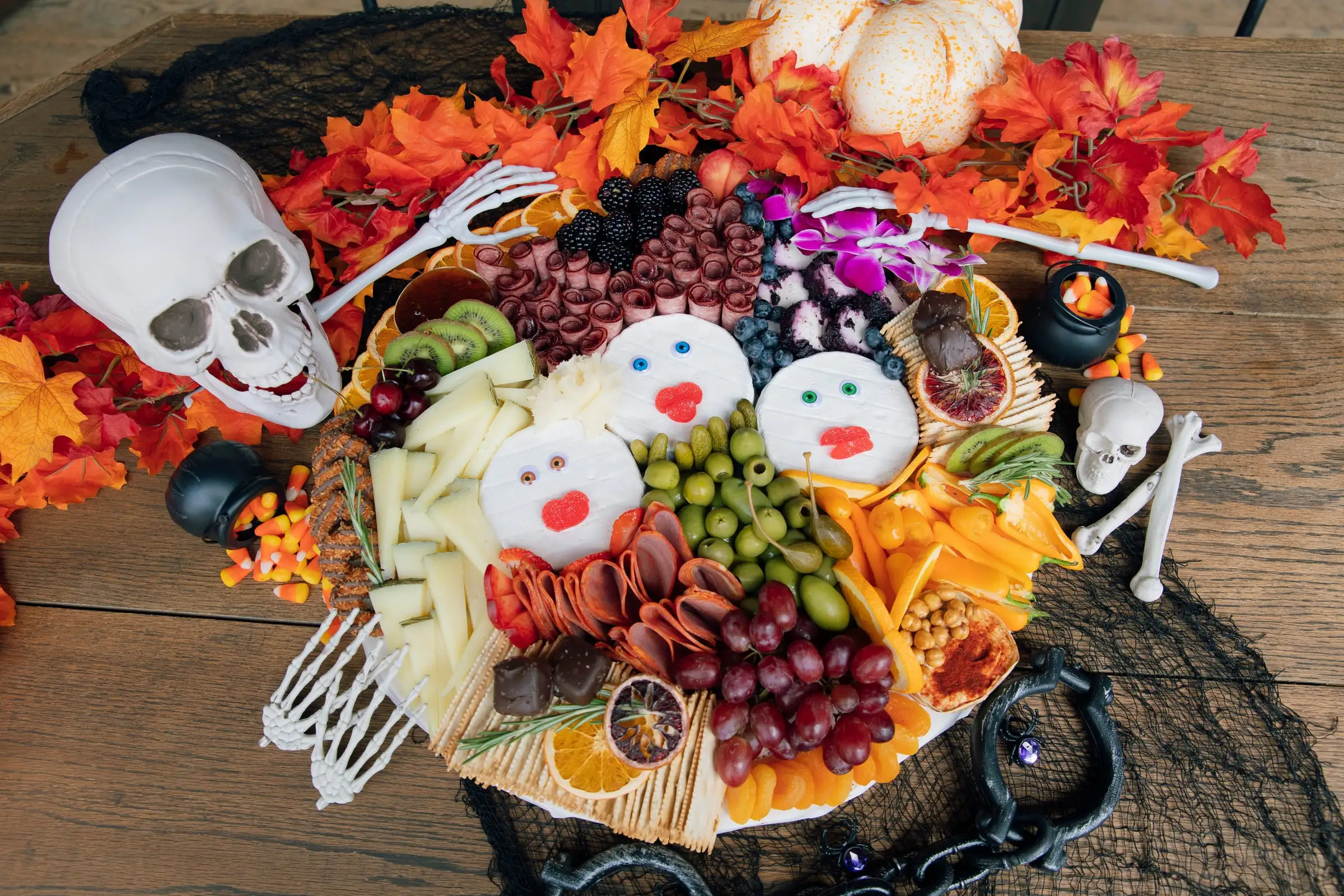 Halloween charcuterie board with cheese ghosts, cured meats, grapes and olives
