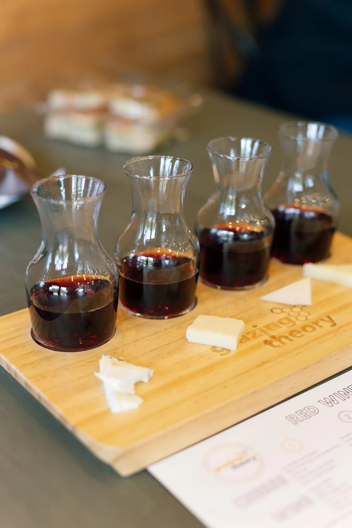 Red wine carafes with cheeses on a wooden board