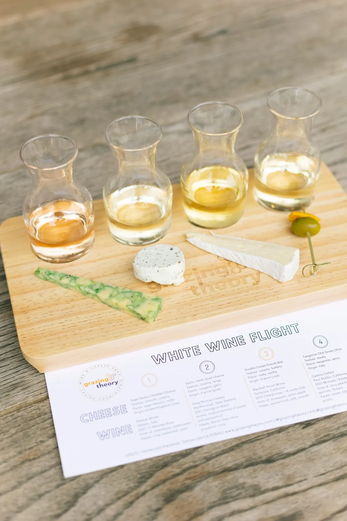 A white wine flight with a cheese in front of each glass